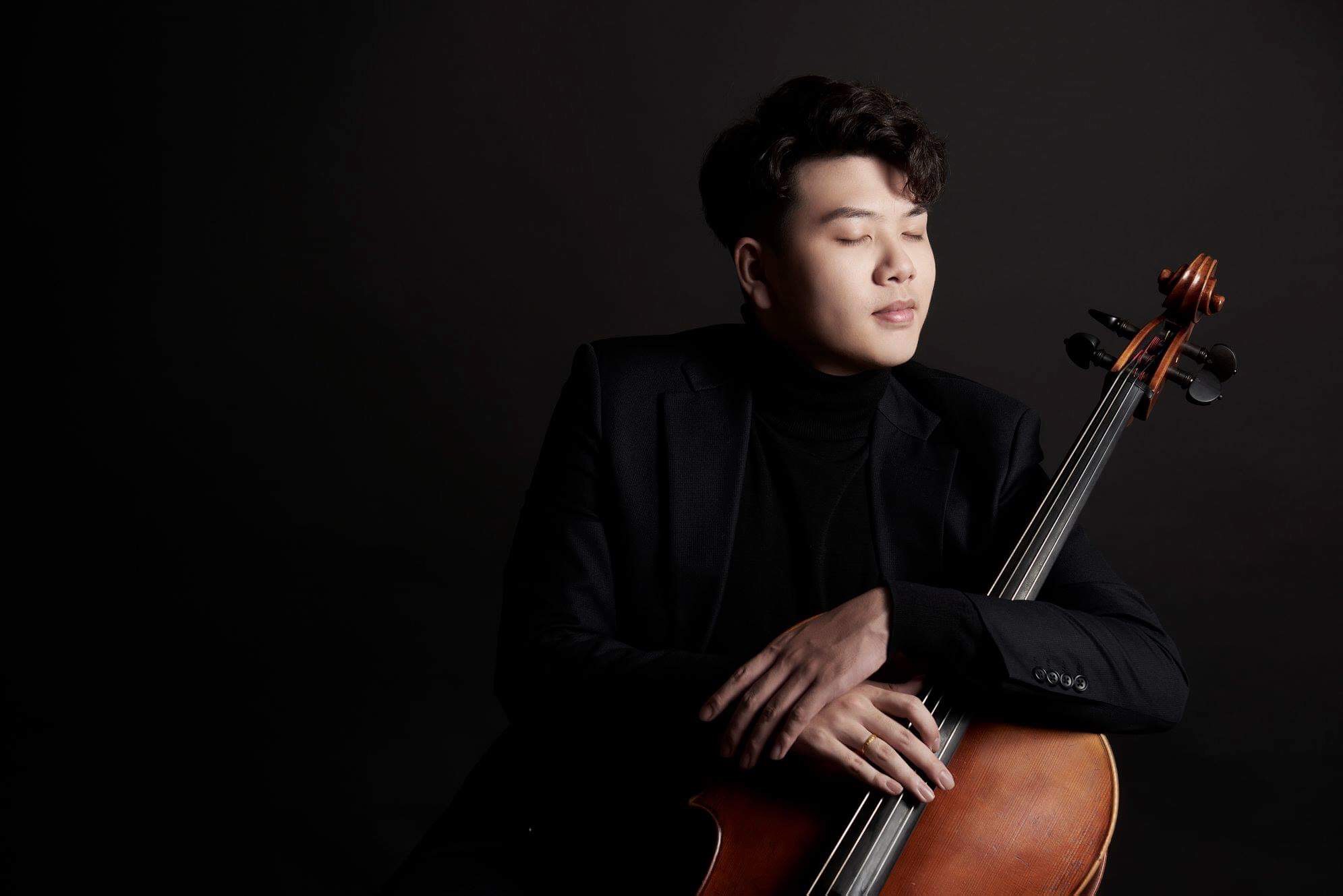 Cellist Yun Ho with his cello in a studio portrait