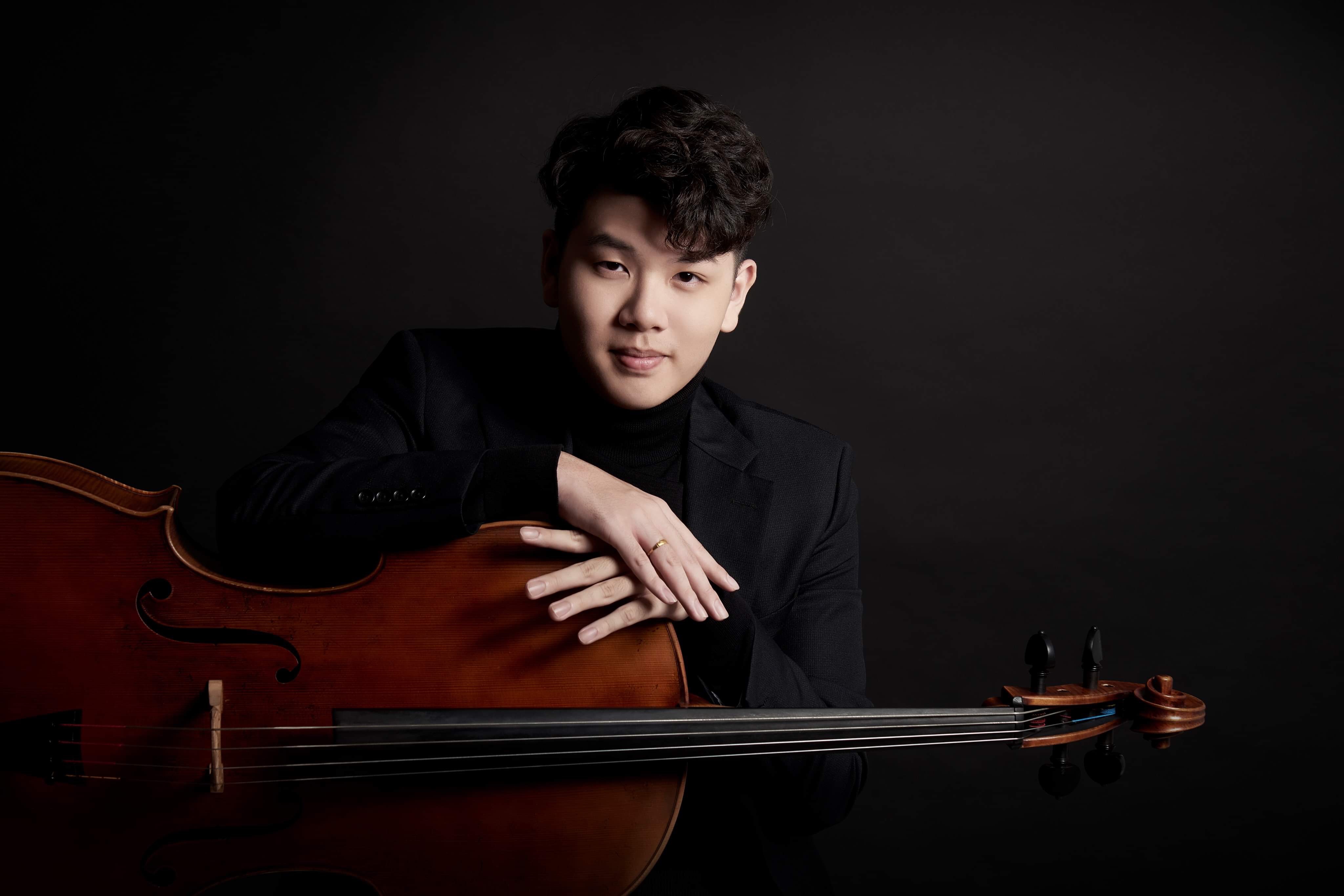 Yun Ho looking toward the camera over his cello